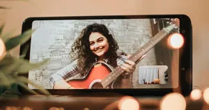 A guitarist appearing within the viewfinder of a mobile phone.