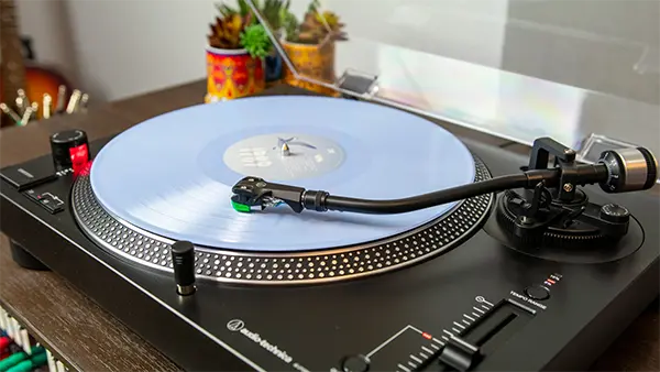 An image of a turntable playing Taylor Swift's 1989 Taylor's Version (blue vinyl).