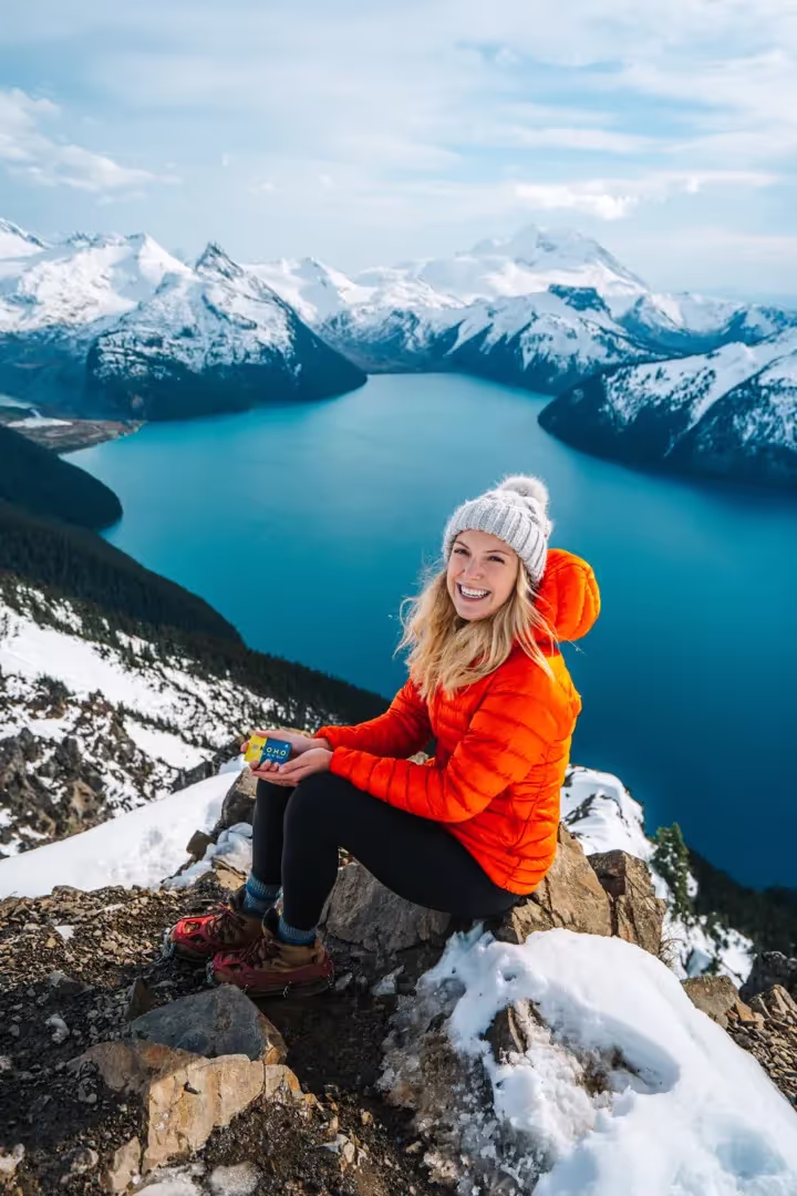 Woman standing on a hill overlooking a large lake in the winter